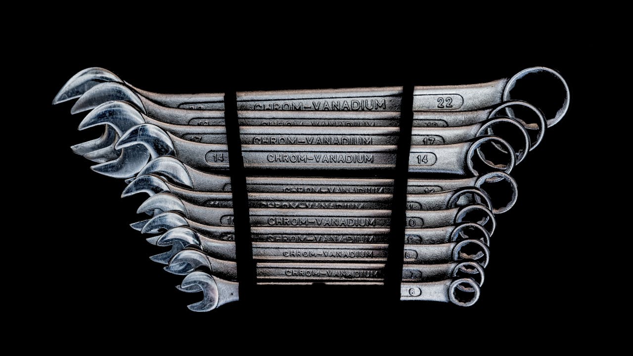 Set of chrome-vanadium wrenches neatly organized on a black background.